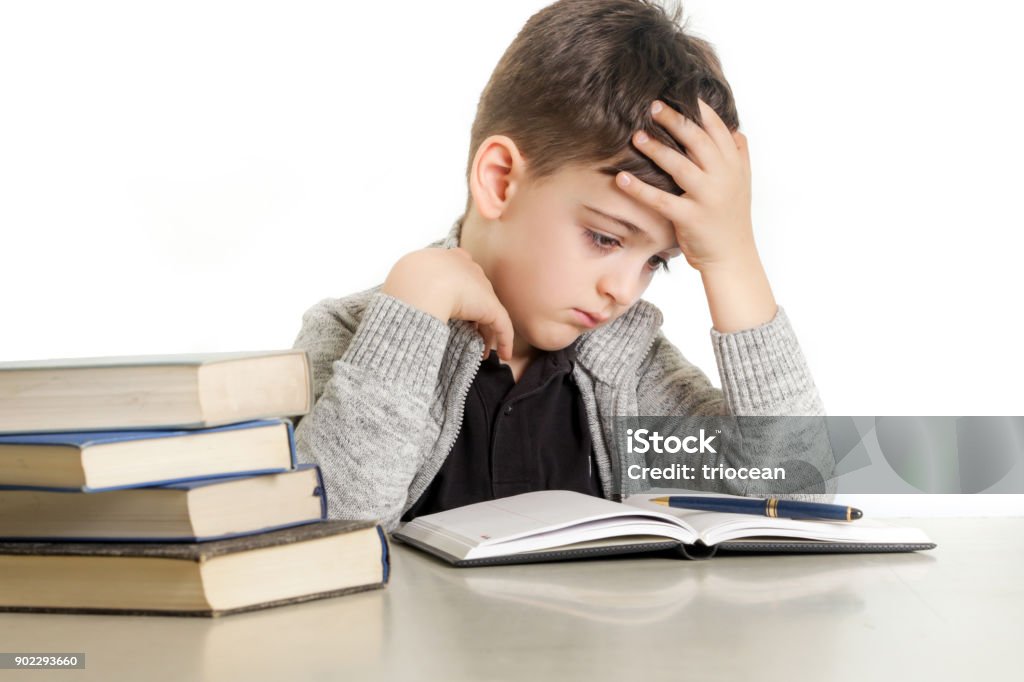 Studio portrait of young boy struggling with his homework - learning difficulties concept Child Stock Photo