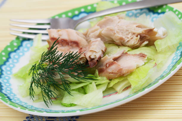 istock Smoked mackerel on crunchy iceberg lettuce, closeup 902300408