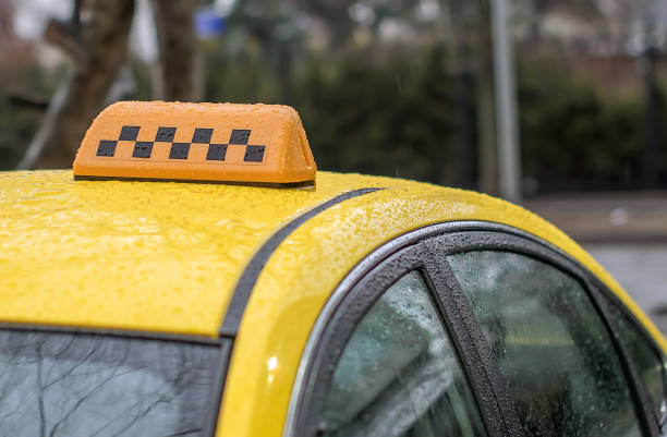 yellow taxi in the rain waiting for passengers stock photo