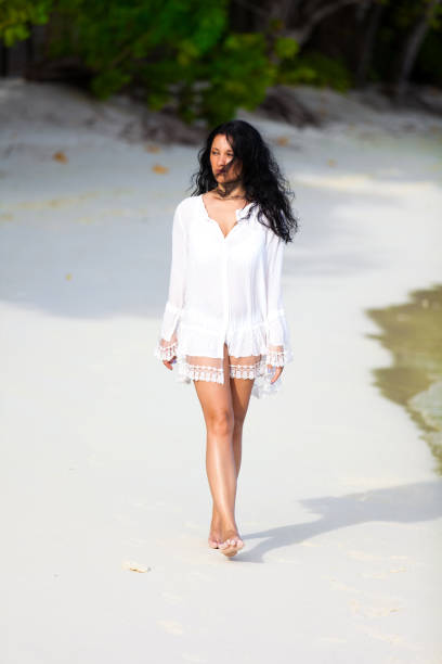 istock Beautiful girl is walking on the beach 902312786