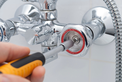 plumber repairs the faucet in the bathroom