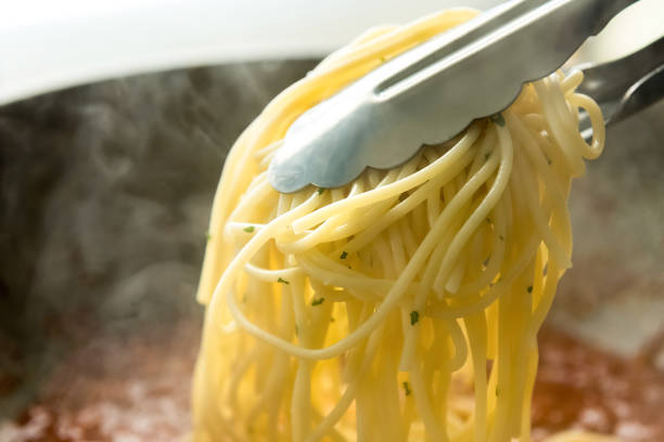 istock Cooked spaghetti pasta lifted by tong 902338510