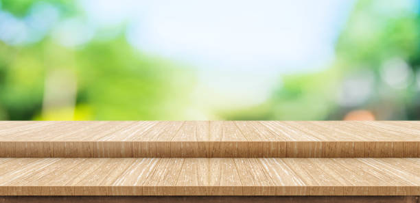 istock Empty step wood table top food stand with blur green park tree background bokeh light,Mock up for display or montage of product,Banner for advertise on online media,nature business presentation 902341018