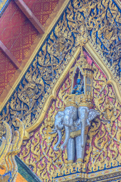 bella scultura di angelo che cavalca tre teste elefante all'estremità del timpano della chiesa buddista nel tempio tailandese. - gable end foto e immagini stock