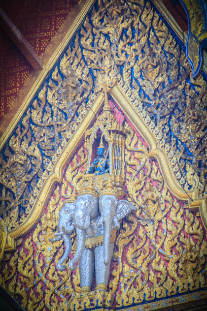 bella scultura di angelo che cavalca tre teste elefante all'estremità del timpano della chiesa buddista nel tempio tailandese. - gable end foto e immagini stock