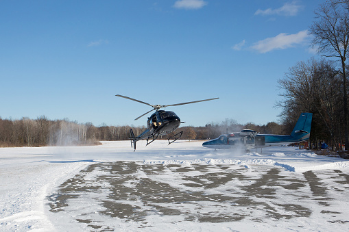 solo black helicopter in blue skies with snow in winter