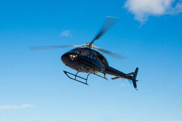 solo black helicopter in blue skies stock photo