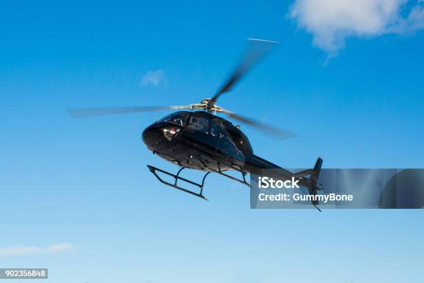 Solo Black Helicopter In Blue Skies Stock Photo - Download Image Now - Helicopter, Flying, Landing - Touching Down