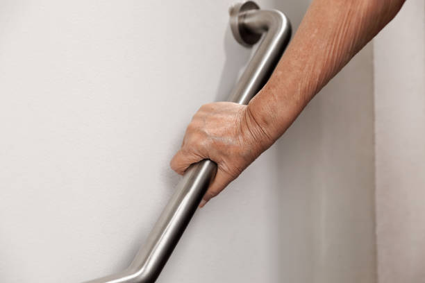 istock Elderly woman holding on handrail for safety walk steps 902372342