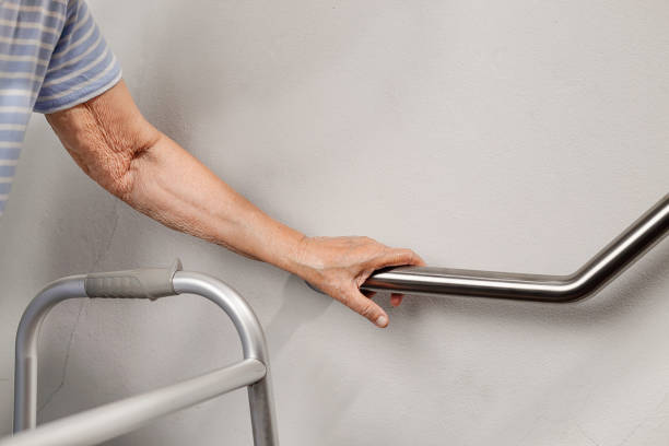 Elderly woman holding on handrail for safety walk steps Elderly woman holding on handrail for safety walk steps gripping stock pictures, royalty-free photos & images