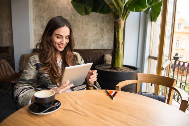 istock Smiling woman using digital tablet at the bar 902378504