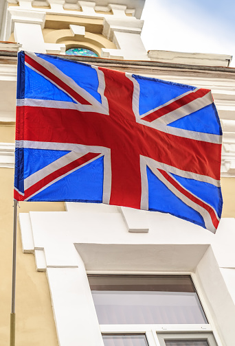 The British flag flies on the building of old hotel in the tourist city