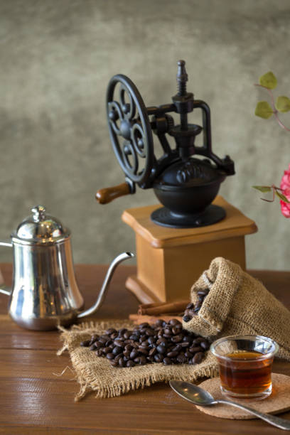 istock Vintage manual coffee grinder with coffee beans and cup 902394246