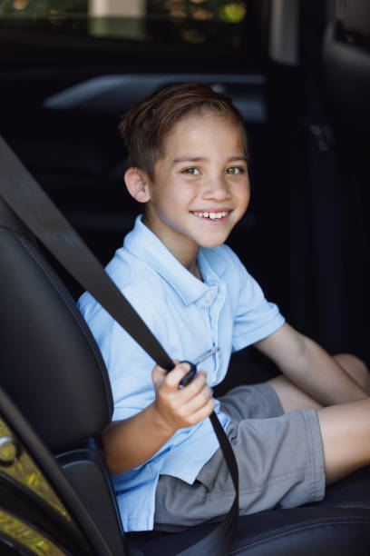 istock Young Boy Putting On Seat Belt 902394312