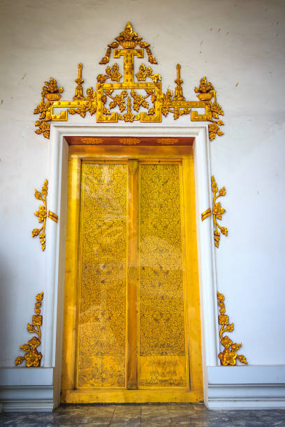 istock Beautiful golden double doors with white plastered wall background in Thai temple. 902394516