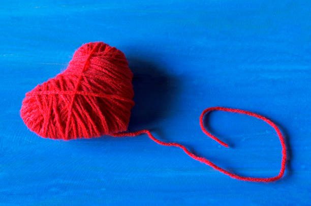 istock Valentine's day backgrounds with Red heart shape made from thread yarn on blue wooden 902397796