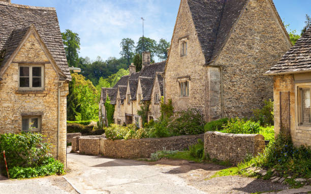 malerische aussicht auf alte straße im sonnigen morgen, bibury, gloucestershir, england, uk. - brick wall old window brick stock-fotos und bilder