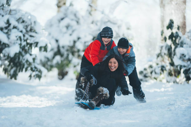 istock Young Mom and Sons Playing in Snow 902407062