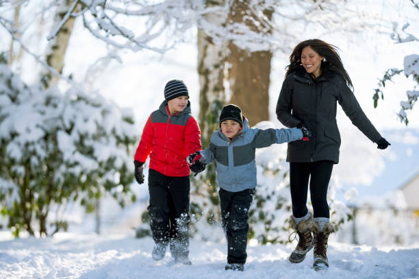 istock Young Mom and Sons Playing in Snow 902407072