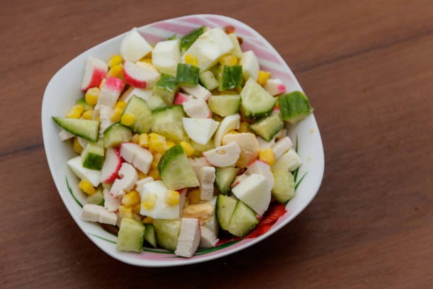istock Salad with crab sticks, sweet corn, cucumber and eggs on wooden table 902407578