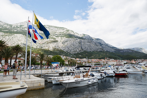 MAKARSKA,CROATIA - 18 JUNE,2017: Motor boats & yachts drifting on water tied to pier in harbor.Popular rental water craft floating on water.Take boat for rent,sail during vacation