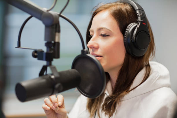 istock Radio Jockey Looking Away While Using Headphones And Microphone 902415092