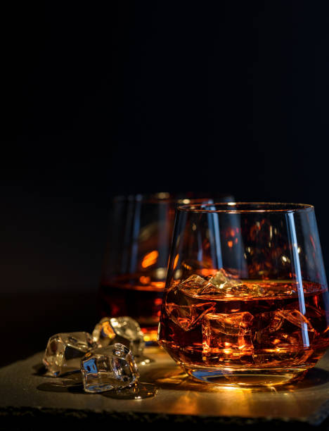 istock Two glasses of whiskey with ice on a black background 902420582