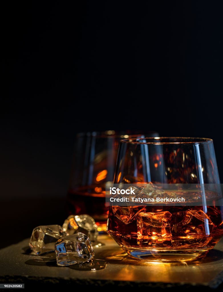 Two glasses of whiskey with ice on a black background Rum Stock Photo