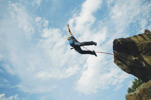A Man Jumps Into A Canyon From A Cliff Stock Photo - Download