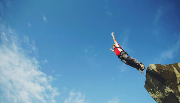 istock A man jumps into a canyon from a cliff. 902425670