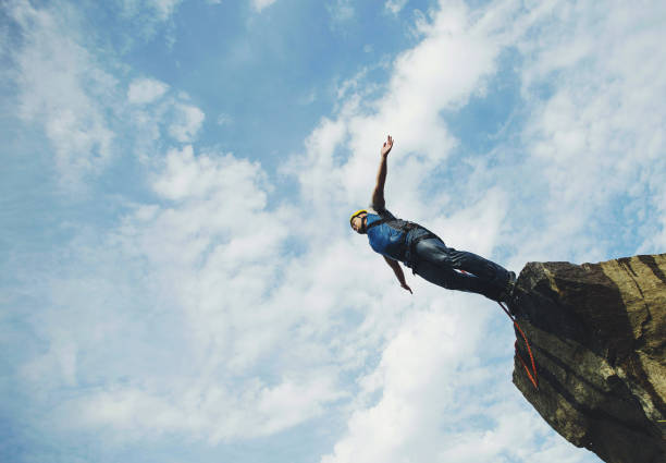 A man jumps into a canyon from a cliff.