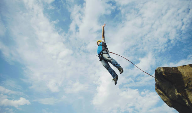 istock A man jumps into a canyon from a cliff. 902425728