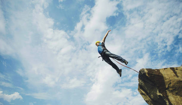istock A man jumps into a canyon from a cliff. 902425740