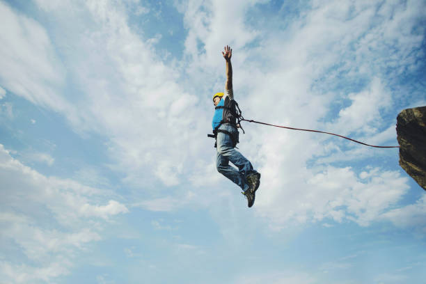 istock A man jumps into a canyon from a cliff. 902425748