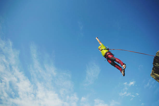 istock A man jumps into a canyon from a cliff. 902425834