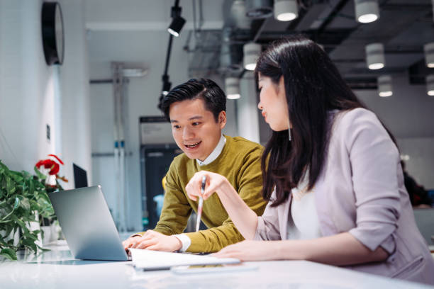 istock Two young Korean entrepreneurs trading cryptocurrencies in modern cafe 902434222