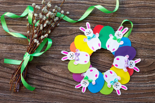 istock Children's Easter gift wreath with colorful eggs and Easter bunnies. Hand-made. Children's art project for children. Craft for kids. 902461912
