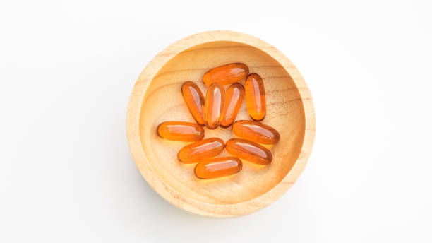 sonnenblumen-öl-kapsel in einer schüssel auf weißem hintergrund. - lecithin capsule brown vitamin pill stock-fotos und bilder