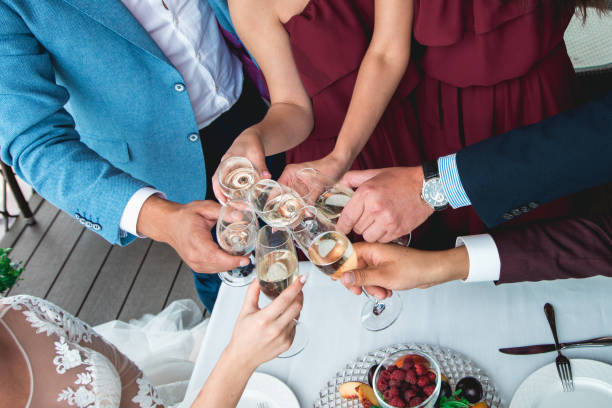 istock People hold in hands glasses with white wine. wedding party. 902464486