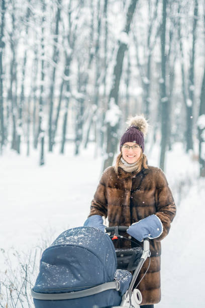 istock Woman walking with stroller in  forest at winter. 902466142