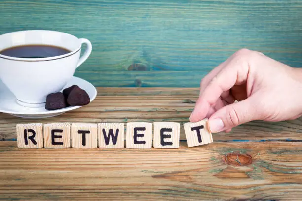 Photo of retweet. Wooden letters on the office desk, informative and communication background