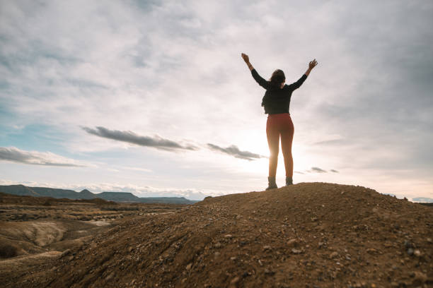 istock Young woman with arms raised 902473228