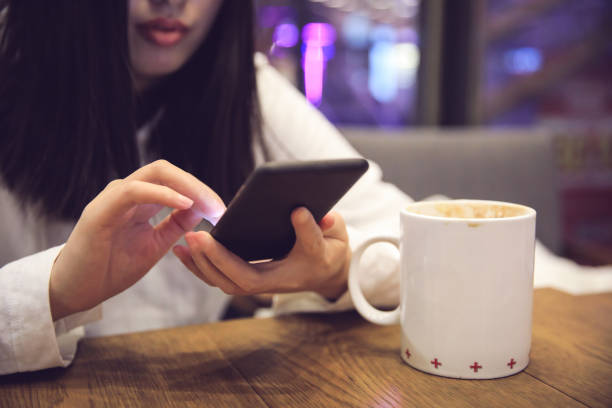 istock Young woman using mobile phone in a cafe 902479144