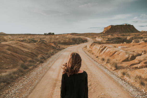 vista posterior de la mujer en la carretera del desierto - una sola vía fotografías e imágenes de stock