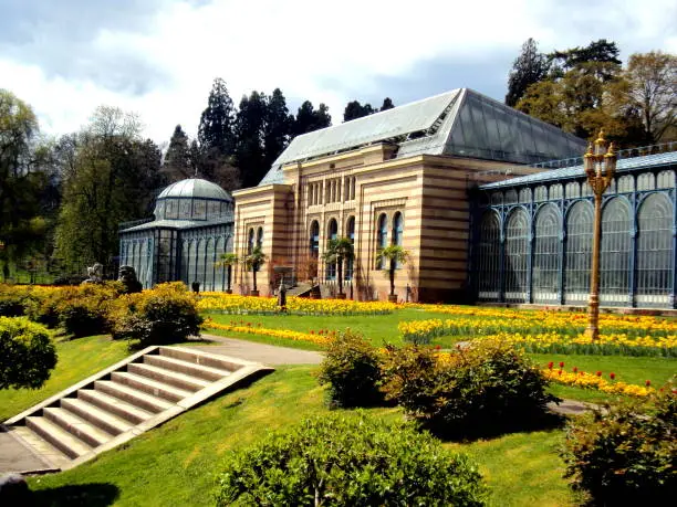 Old green house in beautiful formal garden. in public park with spring flowers in Stuttgart, Germany in Europe