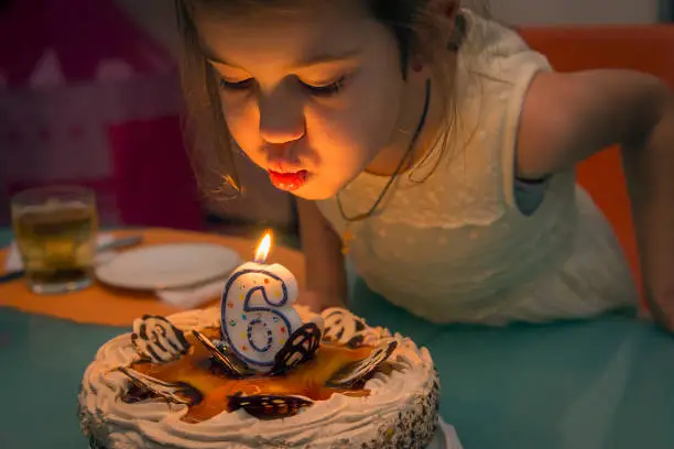 Children's birthday party.Girl blows out a candle,making a wish.