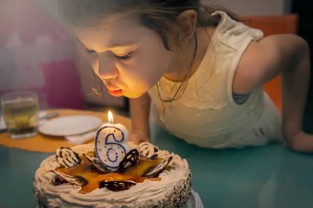 Children's birthday party.Girl blows out a candle,making a wish.