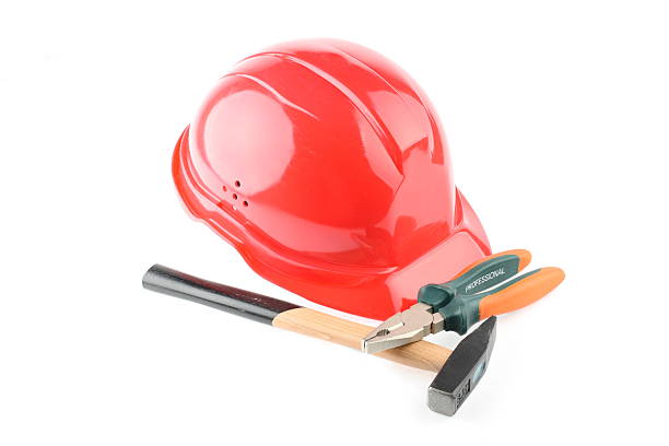 Red helmet, hammer and combination pliers stock photo