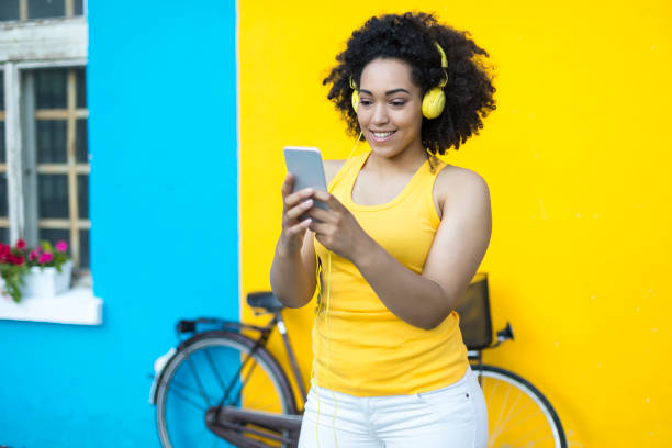 istock Smiling woman with bike using smart phone 902483856