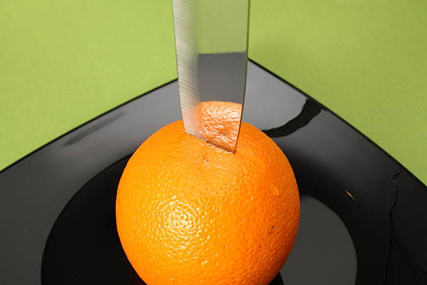 Orange and knife on plate stock photo